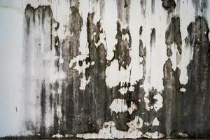 struttura ruvida sulla parete grigia forma ruvida a causa dello strato di vernice scrostato a causa della pioggia. foto