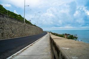 destinazione perfetta per un viaggio su strada durante il tramonto su un'isola del Vietnam. lungo hai panoramico costiero con onde, costa, cielo sereno e strada, mare blu e montagna. foto