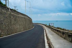 destinazione perfetta per un viaggio su strada durante il tramonto su un'isola del Vietnam. lungo hai panoramico costiero con onde, costa, cielo sereno e strada, mare blu e montagna. foto