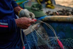 pescatore che getta la sua rete all'alba o al tramonto. i pescatori tradizionali preparano la rete da pesca foto