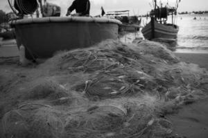 reti da mare - attrezzatura da pesca o attrezzatura come sfondo a trama con luce solare e ombra naturali. sfondo testurizzato bianco e nero di reti da pesca primo piano, design marino per imbarcazioni di pescatori. foto