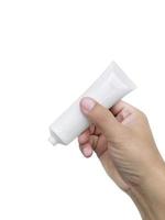 mano umana che tiene tubo di plastica cosmetico isolato su sfondo bianco foto