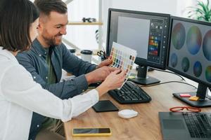 scegliendo i colori giusti. due designer che lavorano insieme in ufficio foto