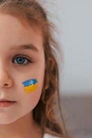 vista ravvicinata. ritratto di bambina con bandiera ucraina make up sul viso foto