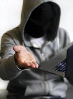 ransomware - hacker con laptop che chiede denaro foto