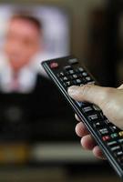 telecomando e schermo - abbuffarsi di guardare il programma televisivo preferito foto