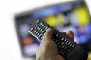 telecomando e schermo - abbuffarsi di guardare il programma televisivo preferito foto