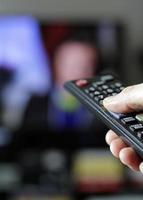 telecomando e schermo - abbuffarsi di guardare il programma televisivo preferito foto