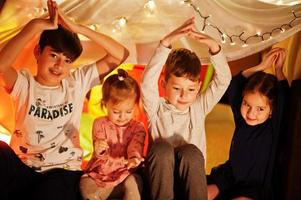 giocare con i bambini in tenda di notte a casa. umore hygge. foto