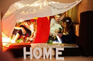 giocare ai bambini con il gattino in tenda di notte a casa. umore hygge. foto