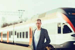 l'uomo si trova vicino a un treno moderno foto