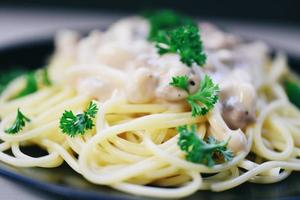 spaghetti alla carbonara pasta italiana servita su piatto bianco con prezzemolo nel ristorante foto