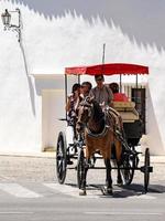 ronda, andalucia, spagna, 2014. turisti che si godono un giro in una carrozza trainata da cavalli a ronda spagna l'8 maggio 2014. persone non identificate. foto