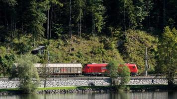 hallstatt, austria, 2017. treno merci che corre lungo il bordo del lago hallsattt foto