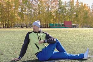 uomo bello che indossa abbigliamento sportivo caldo facendo esercizi di stretching foto