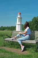 donna di mezza età con capelli castani che guarda un faro foto