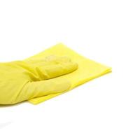 la mano di un uomo in un guanto giallo tiene un panno per la pulizia giallo isolato su uno sfondo bianco foto