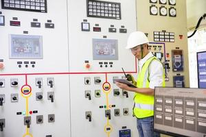 gruppo di ingegneri elettrici che lavora sul pannello di controllo anteriore, lavoro di formazione per ingegneri con pannello di controllo nella sala di servizio. foto