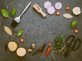 concetto di bistecca con sfondo di pietra scura. ingredienti per fare la bistecca con spazio di copia. erbe aromatiche e condimenti rosmarino, salvia, alloro, basilico, aglio e pepe in grani. foto