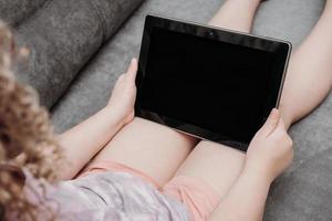 bambina che tiene il tablet pc. istruzione in linea. foto