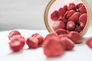 fragola secca sublimata che fuoriesce da un barattolo. ingrediente dolciario per dolci e dolci. messa a fuoco selettiva foto