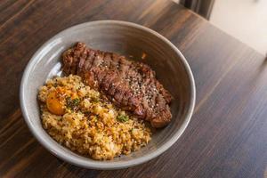 Riso fritto all'aglio grasso di manzo con guarnizione di bistecca di manzo con tuorlo d'uovo sottaceto foto