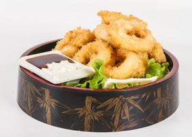 Anelli di calamari fritti in pastella con insalata verde foto