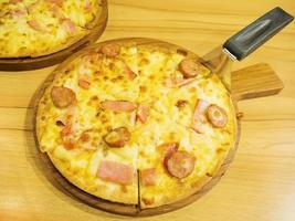 pizza e cucchiaio sollevatore sul vassoio di legno foto
