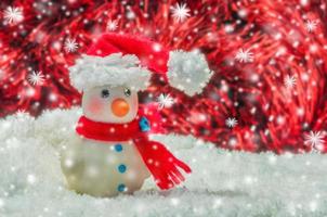 uomo di neve su sfondo sfocato rosso e bianco per la decorazione di Natale e Capodanno foto