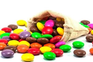 caramelle al cioccolato colorate in mini borsa a sacco su sfondo bianco foto