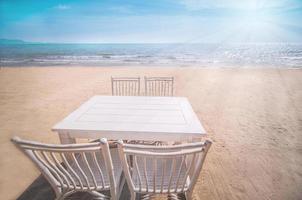 set bianco di sedie e tavolo rilassanti sulla spiaggia di pataya, tailandia con cielo blu e sfondo chiaro del sole foto