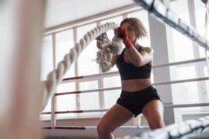 giornata ordinaria di sportiva. la bionda fa esercizio con le corde in palestra. femmina forte foto