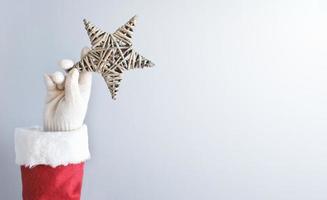 la mano di Babbo Natale che tiene una stella di natale. foto