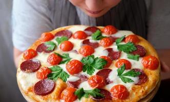 menu ristorante pizzeria italiana. pizza ai peperoni con mozzarella, salame, pomodorini e coriandolo. foto