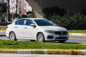 antalya turchia 04 marzo 2022 fiat egea bianca sta guidando per strada in una calda giornata autunnale foto