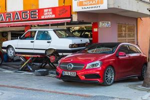 Antalya Turchia 04 marzo 2022 giallo tofas dogan auto su un ascensore in un negozio di pneumatici e rosso mercedes-benz a-class foto