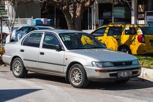 antalya turchia 04 marzo 2022 silver toyota corolla è parcheggiata sulla strada in una calda giornata sullo sfondo di un edificio, negozi foto