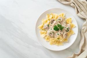 farfalle con salsa di panna bianca ai funghi foto