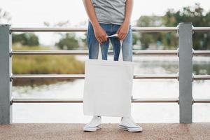 donna hipster con tote bag bianca nel parco foto