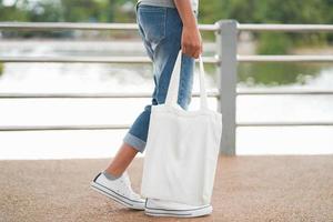 donna hipster con borsa di cotone bianco al parco foto