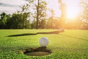 giocatore di golf che mette la pallina da golf nella buca foto