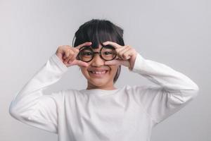 concetto di educazione, scuola e visione - bambina carina sorridente con gli occhiali neri foto