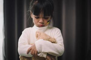 un bambino con la bandiera dell'ucraina sta piangendo. tristezza brama speranza. lacrime di bambini dalla guerra. evacuazione dei civili. libertà in Ucraina foto