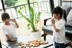 bambini che giocano con un barattolo di latta e un telefono a corde come concetto di comunicazione foto