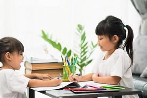 covid-19 coronavirus e apprendimento da casa, concetto di bambino a scuola a casa. i bambini piccoli studiano online imparando da casa con il laptop. foto