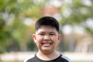 il ritratto del bambino asiatico carino il piccolo sorriso del ragazzo tailandese fa un concetto di faccia felice. foto