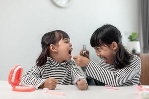 carino bambino asiatico che gioca con il set di giocattoli medico dentista, il bambino mostra come pulire e prendersi cura dei denti. odontoiatria e medicina, foto