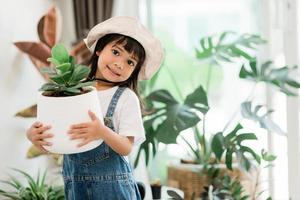 piante in vaso a casa tenute da un bambino carino foto