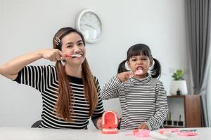 famiglia felice e salute. madre e figlia ragazza lavarsi i denti insieme foto