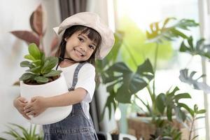 la bambina asiatica sta piantando piante in casa, concetto di attività di apprendimento per la coltivazione di piante per un bambino in età prescolare e educazione del bambino per l'albero in natura foto